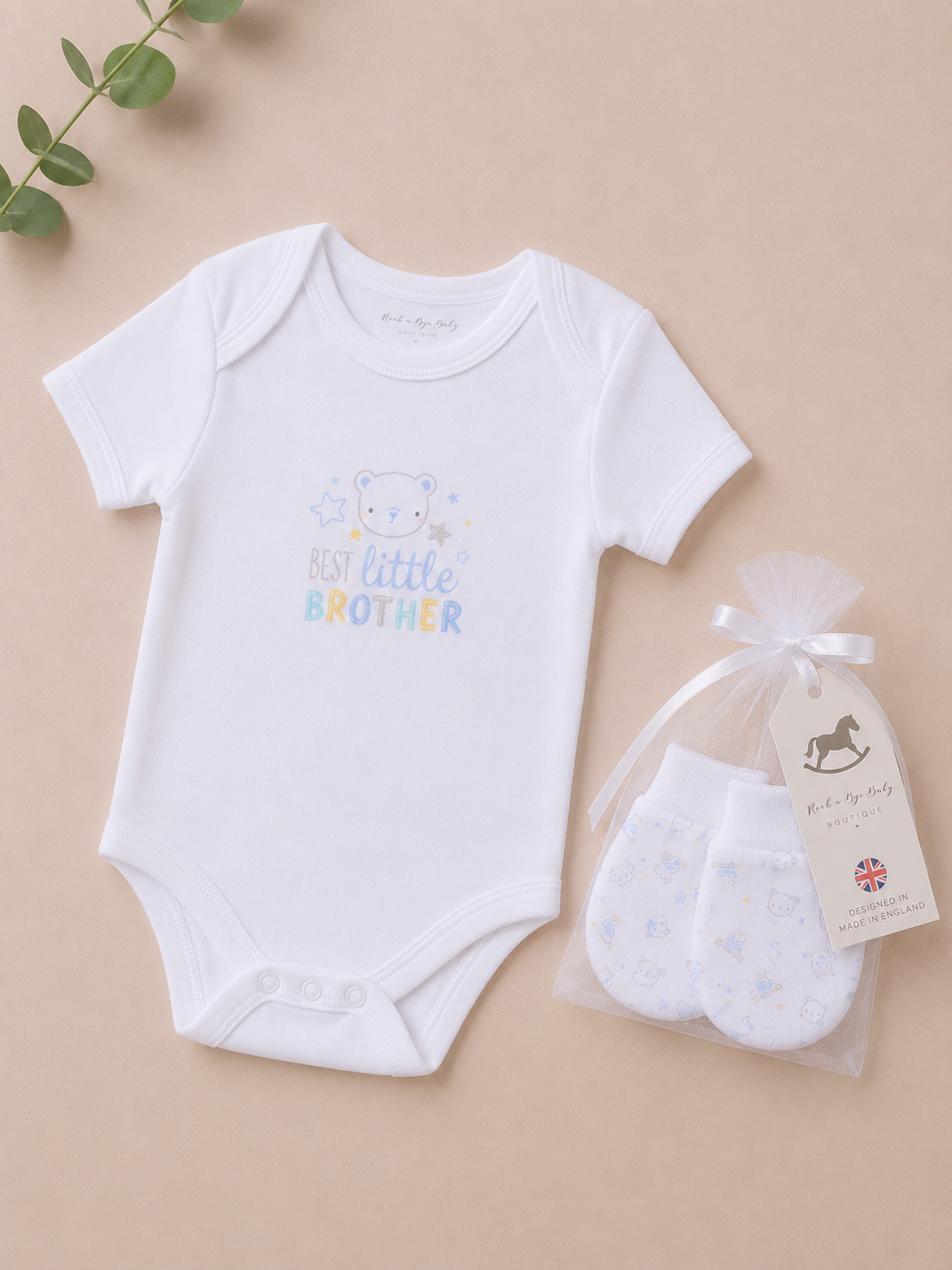 Baby bodysuit with 'My Little Brother' text and a pair of baby socks on a beige background