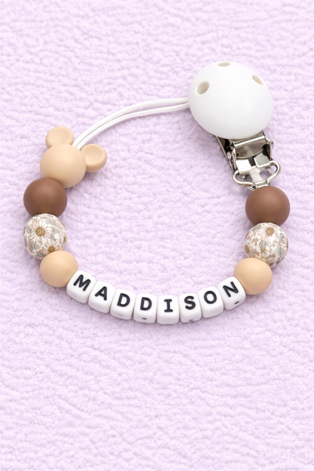 Beaded pacifier clip with 'MADDISON' on a pink background