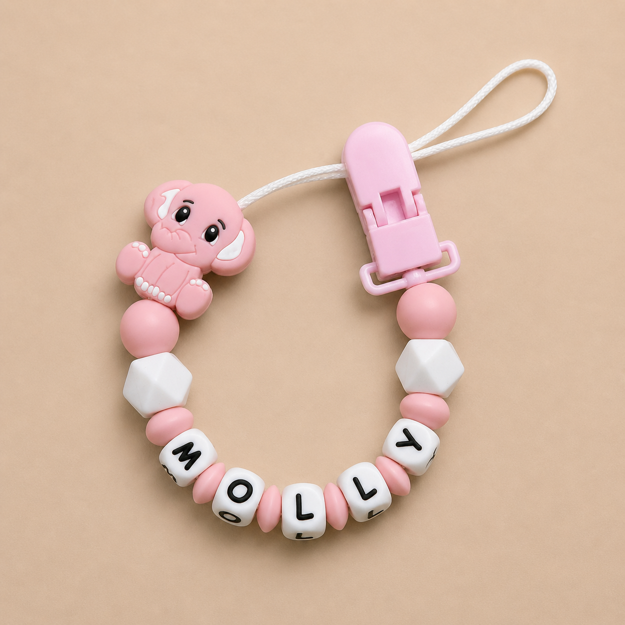 Pink and white dummy clip with 'MOLLY' beads on a beige background