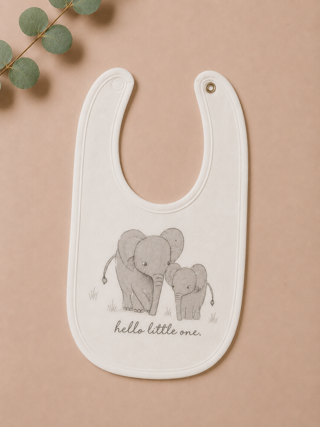 Baby bib with elephant design and 'hello little one' text on a beige background