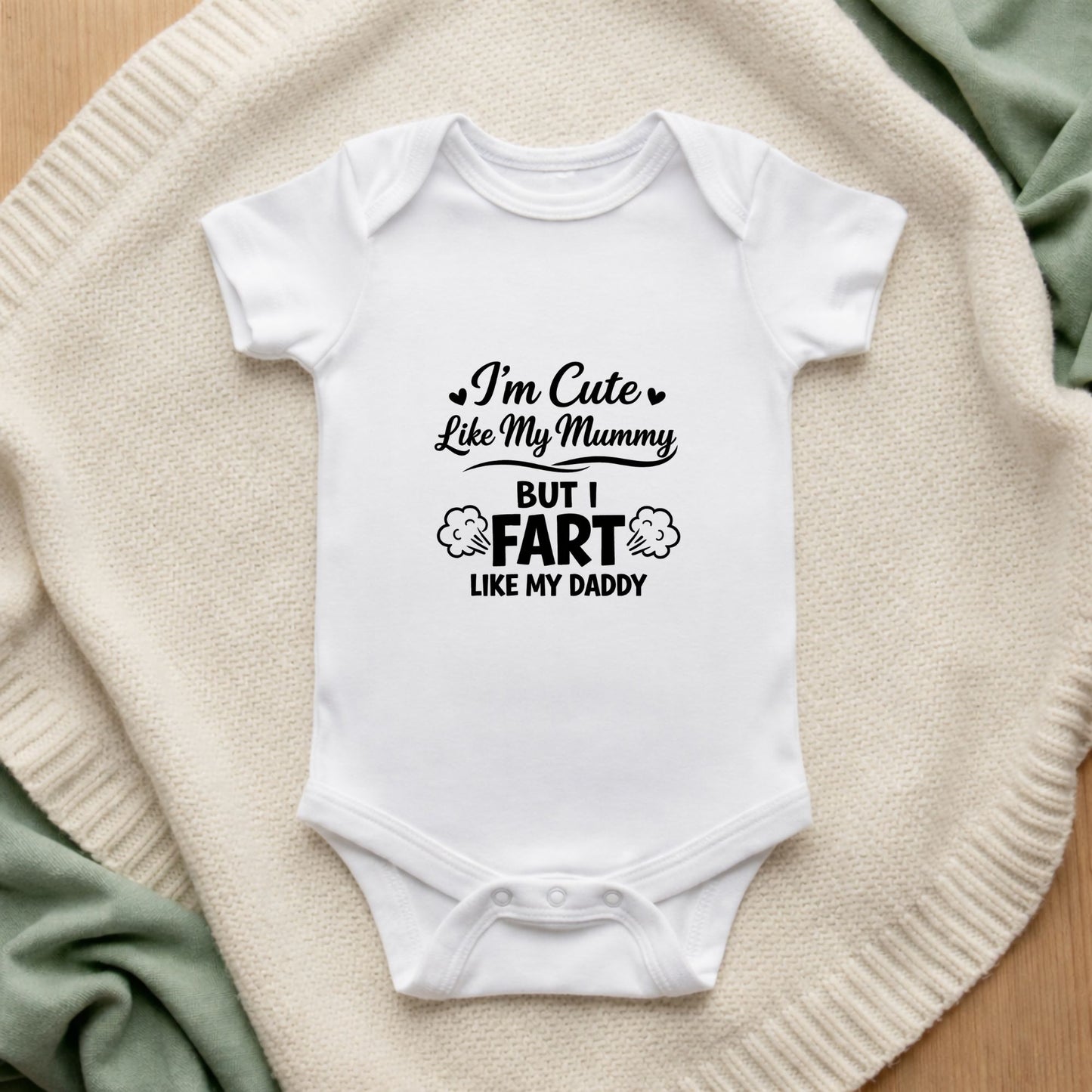 White baby onesie with humorous text on a textured surface I'm Cute Like My Mummy But I Fart Like My Daddy Baby Vest