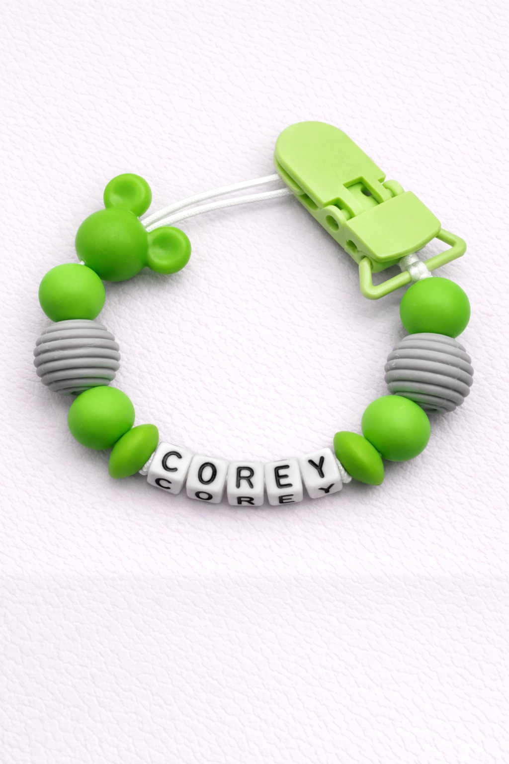 Green and gray dummy clip with a clip on a white background
