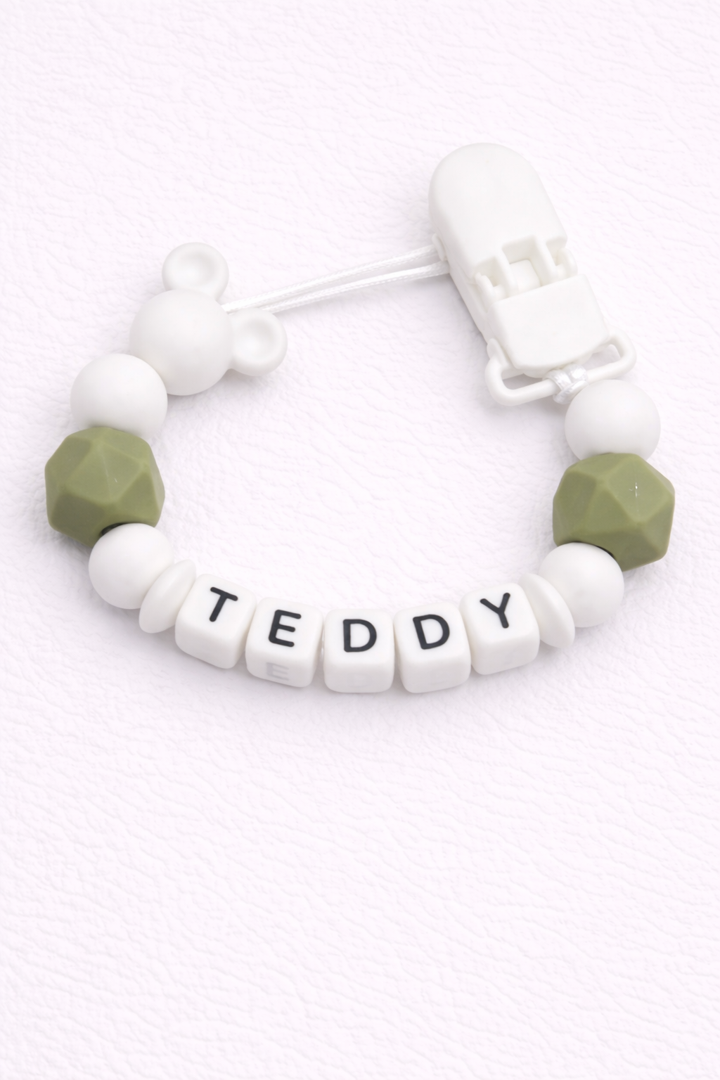 dummy clip with 'TEDDY' beads on a white background