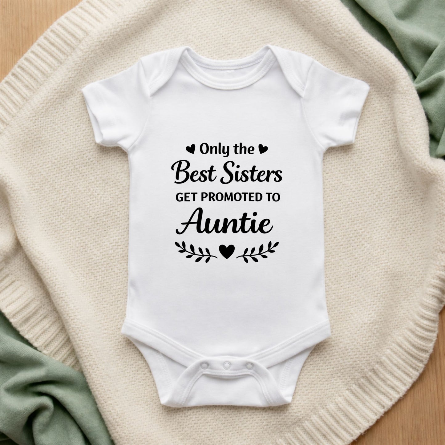 White baby onesie with text on a textured surface Only the Best Sisters Get Promoted to Auntie Baby Vest