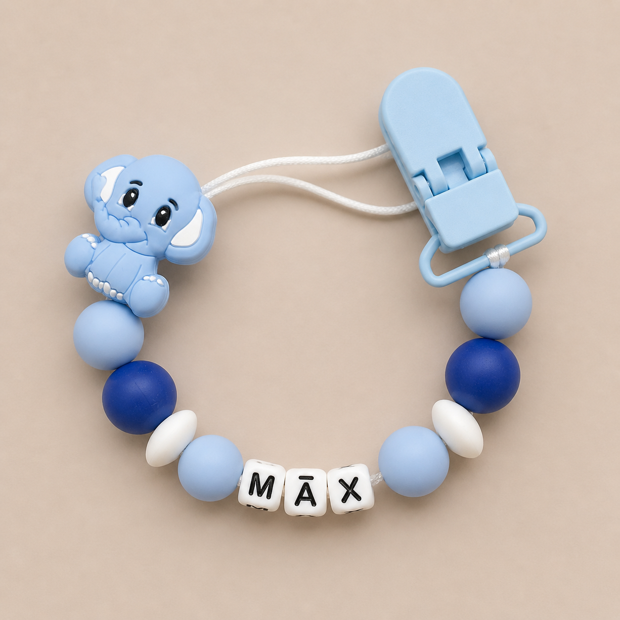 Blue elephant dummy clip with 'MAX' on a beige background