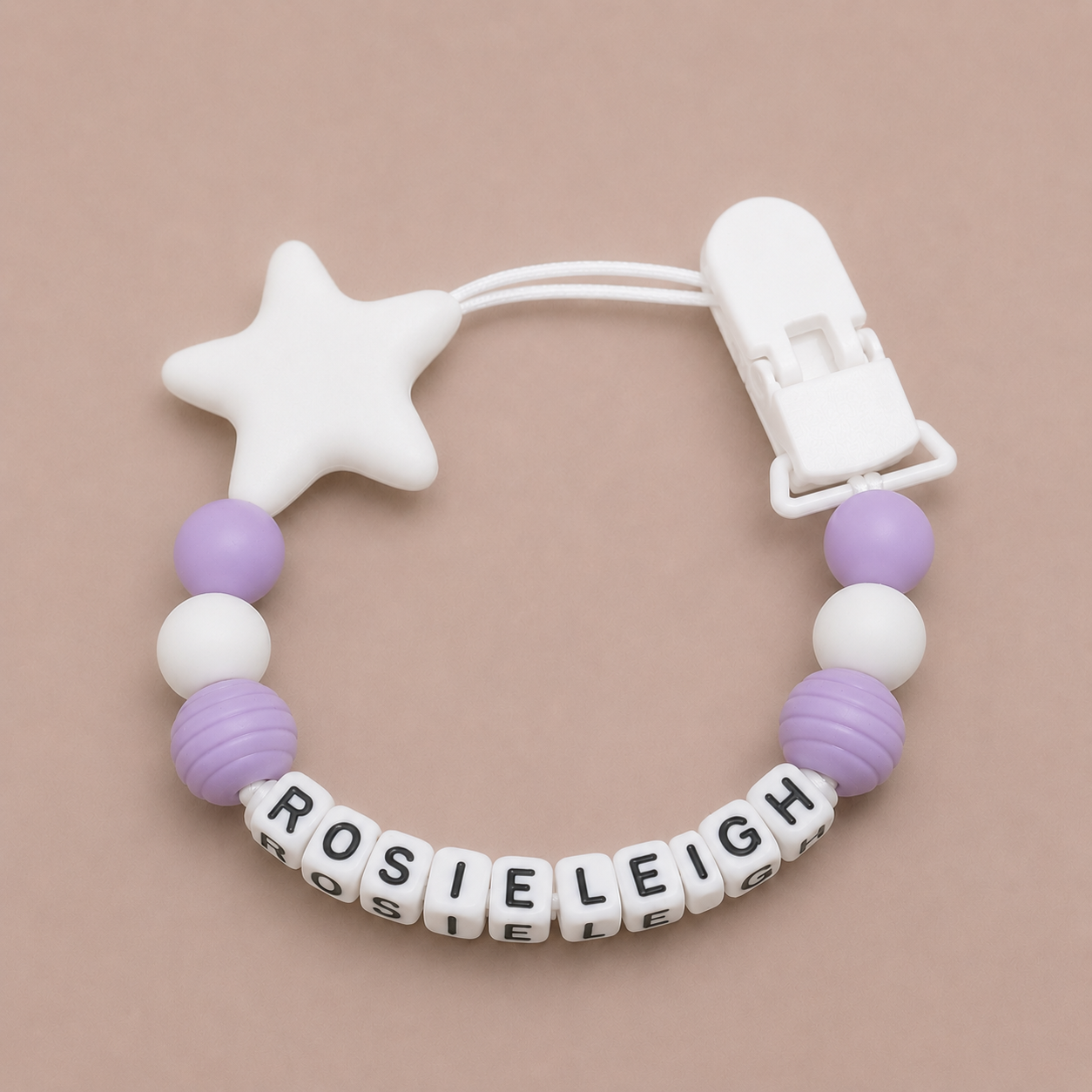 Baby dummy clip with star-shaped handle and personalized name beads on a beige background