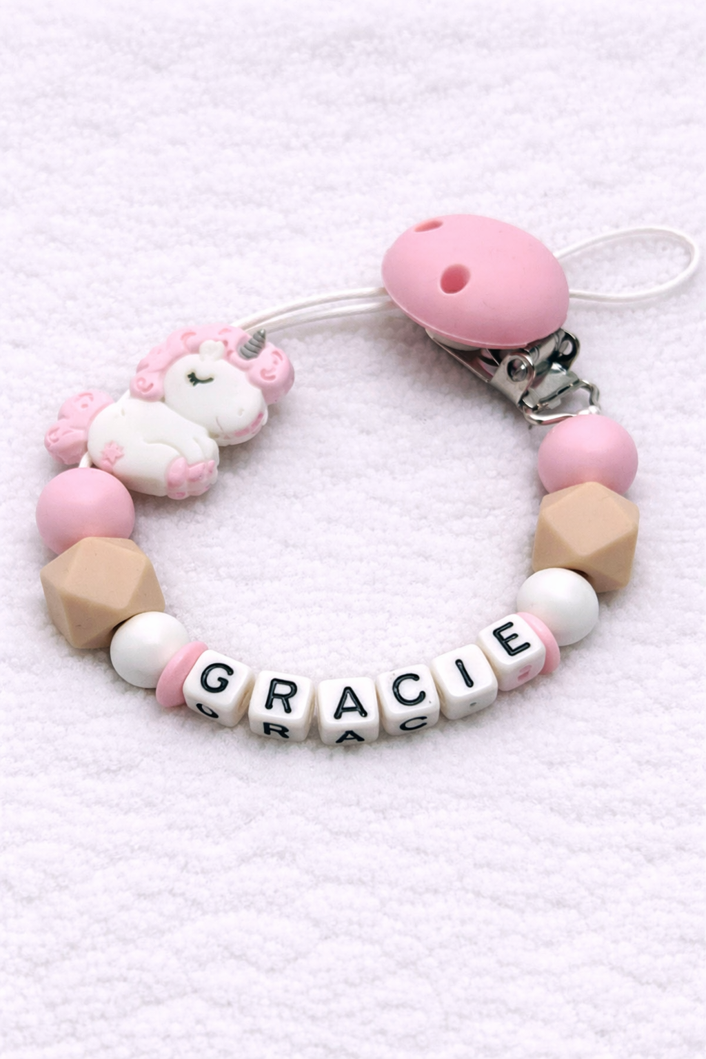 Baby teether with pink and beige beads and 'GRACIE' on a white background