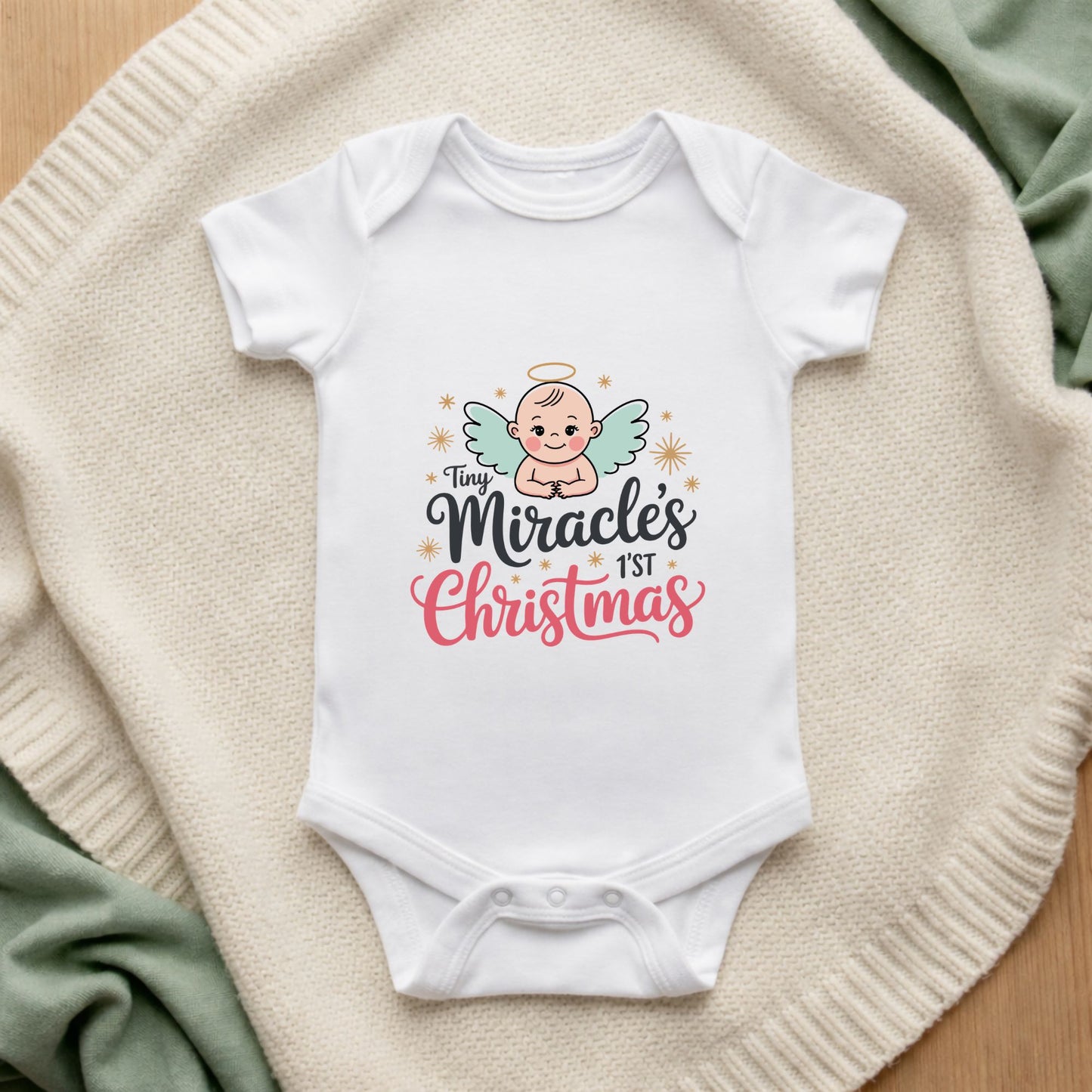 White baby onesie with 'Tiny Miracle's 1st Christmas' design on a textured surface.