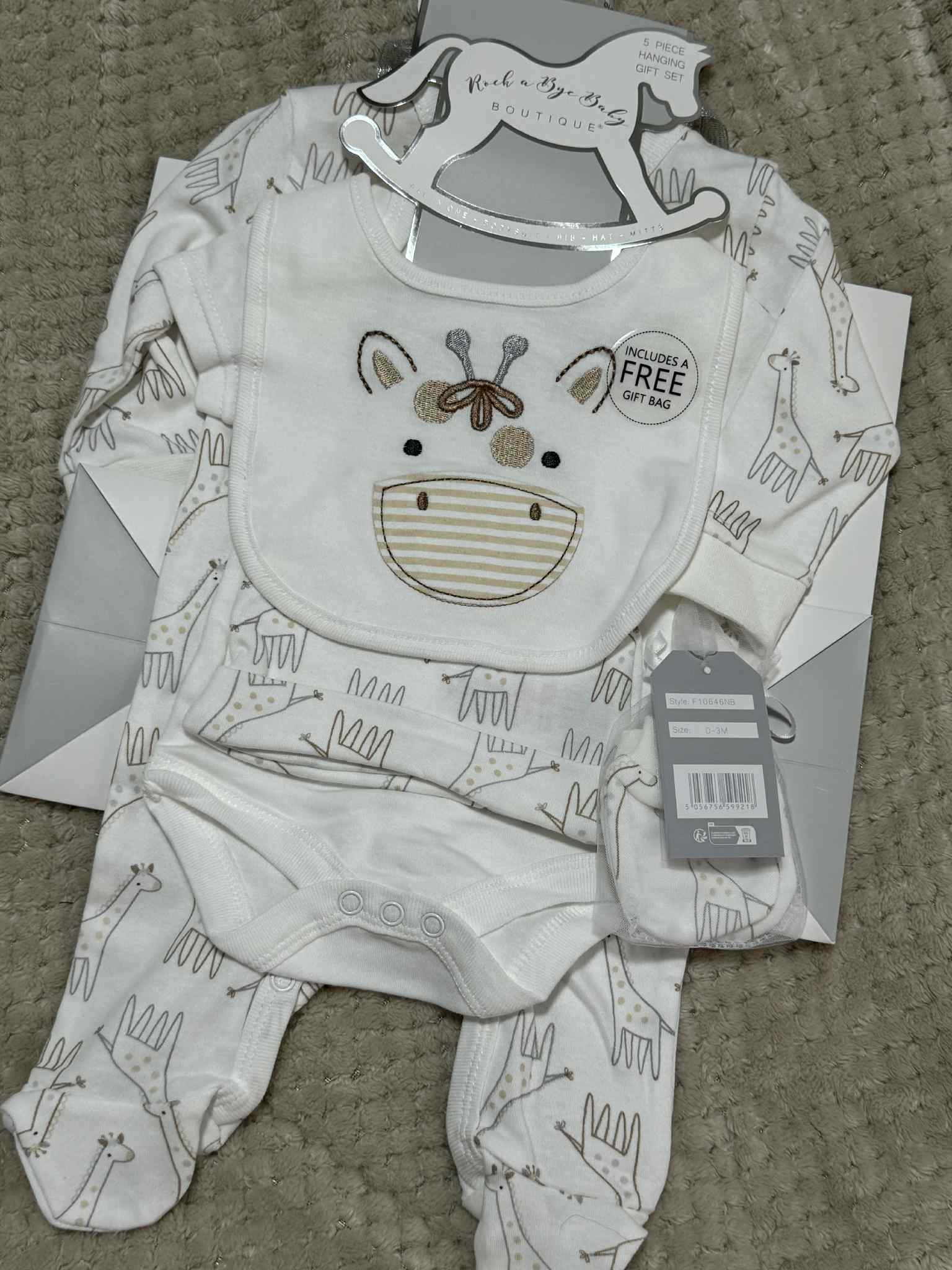 cream with giraffe print sleepsuit, bodysuit, hat, bib and mittens with giftbag