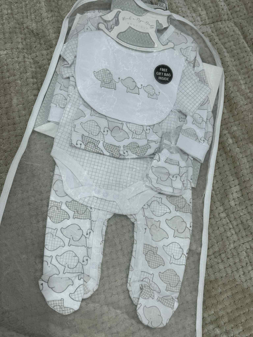Baby bib and footed pants with fish pattern on a textured surface