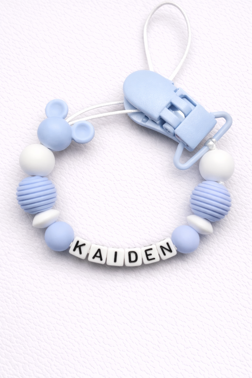 Silicone dummy clip with 'KAIDEN' name on a white background