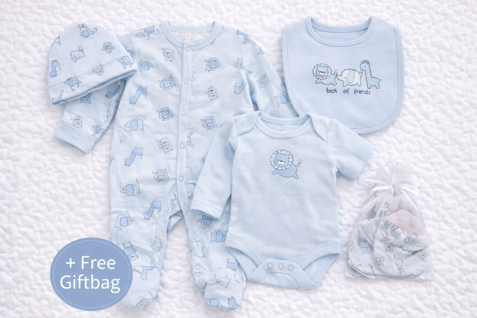 Flat lay of a baby boys blue 5-piece outfit set featuring a long-sleeve animal-print babygrow, matching bodysuit, bib with “Best of Friends” animal design, soft hat, and scratch mittens, neatly presented with a free gift bag.