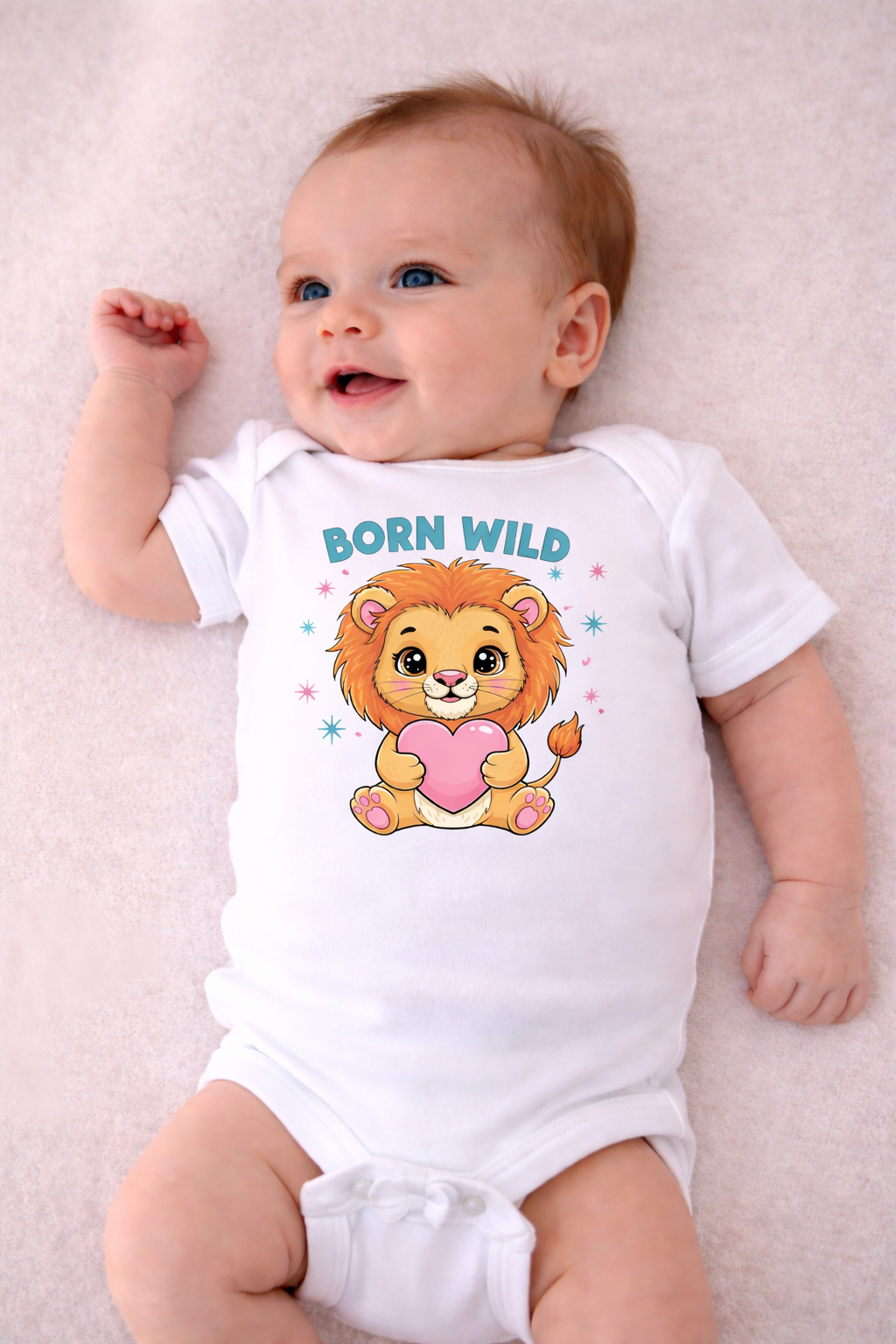 Baby wearing a white onesie with a lion graphic and 'Born Wild' text on a light pink background