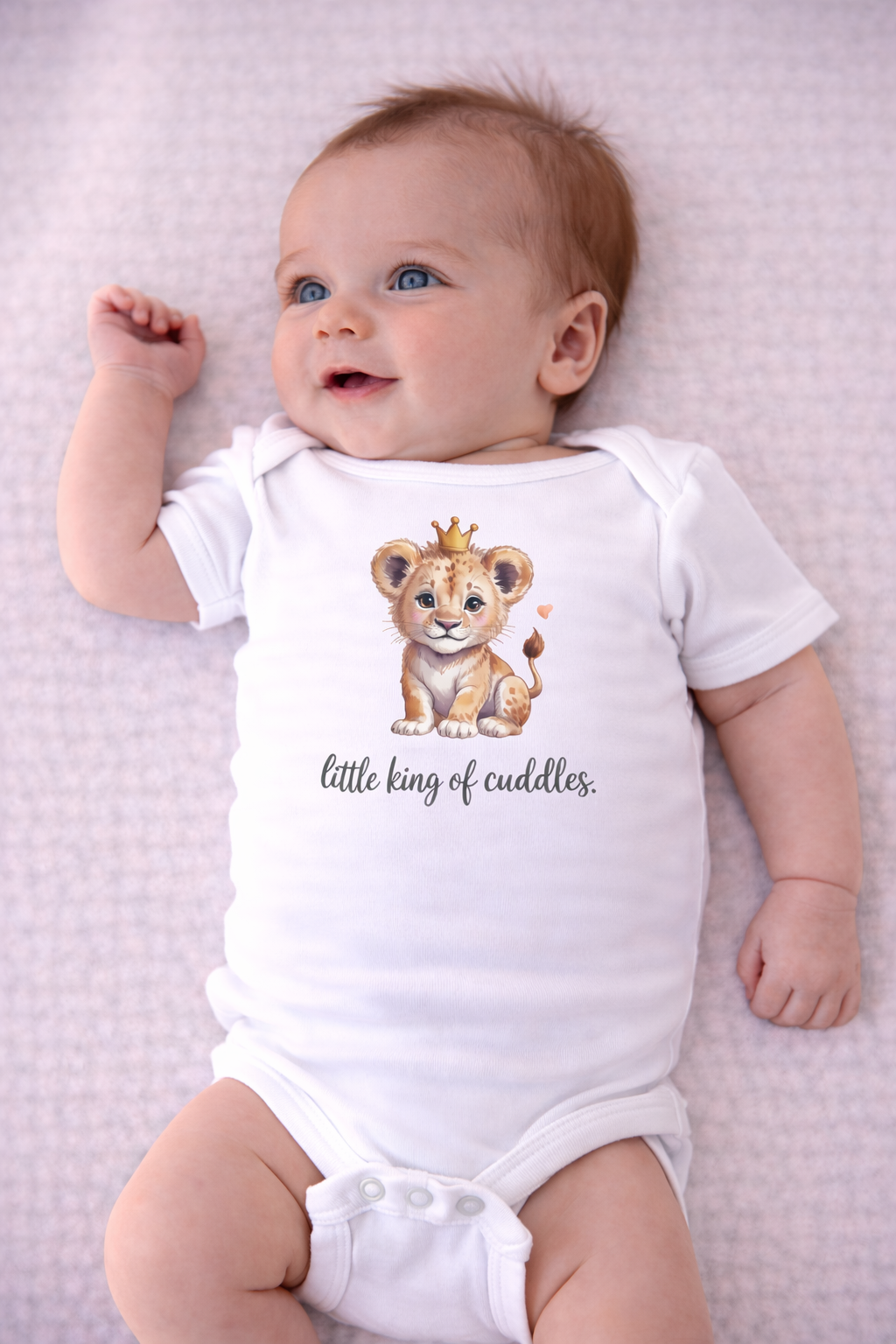 Baby wearing a onesie with a lion design and text on a light purple textured background