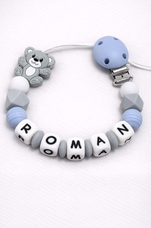 dummy clip with bear charm and name beads on a white background