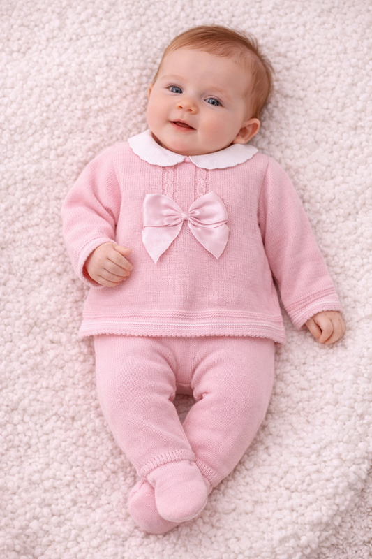 Beautiful Spanish-style knitted baby outfit in pink with white Peter Pan collar and bow detail. Perfect for special occasions and gifts.