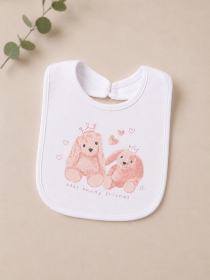 White baby bib with pink teddy bear design on a beige background