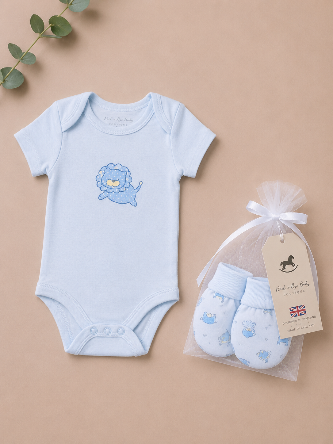 Baby bodysuit with lion design and matching booties on a beige background