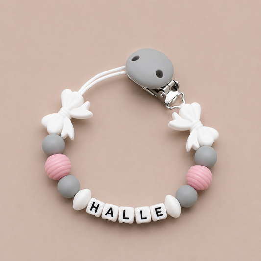 Baby dummy clip with colorful beads and 'HALLE' letter beads on a beige background