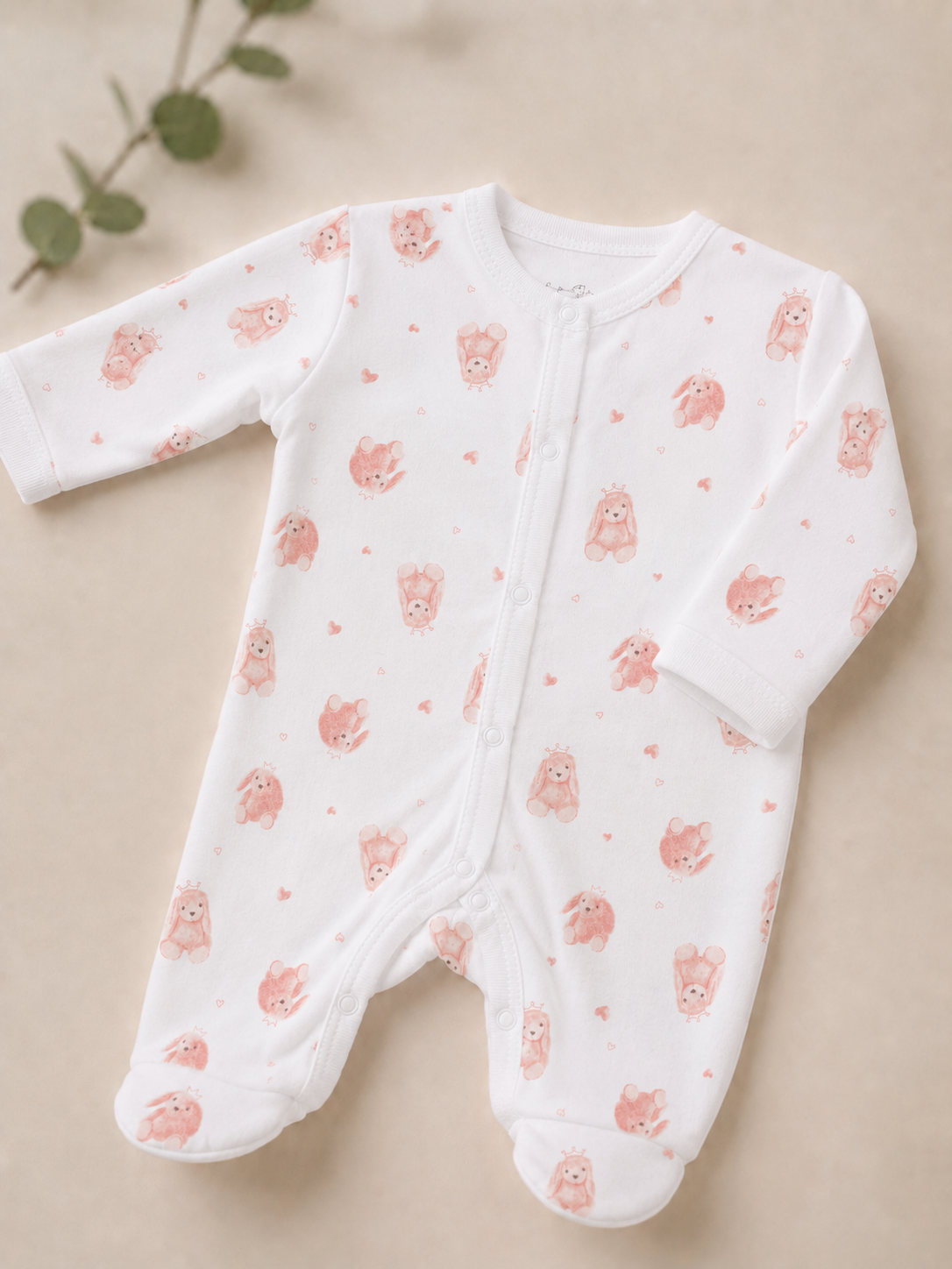 Baby onesie with pink animal pattern on a beige background