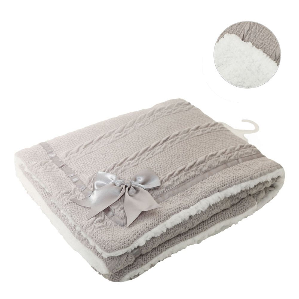 Gray textured blanket with a white sherpa interior on a white background
