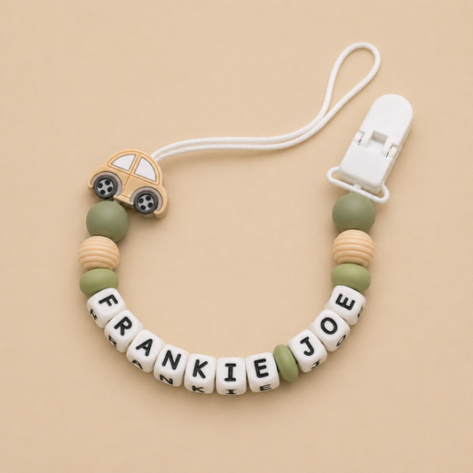 dummy clip with car charm and letter beads on a beige background