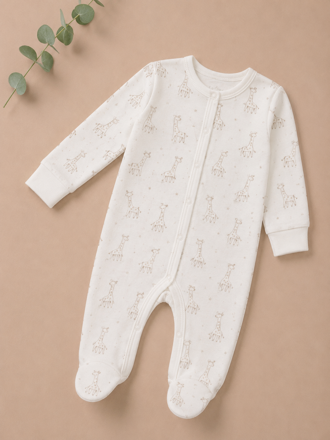 White baby onesie with subtle pattern on a beige background
