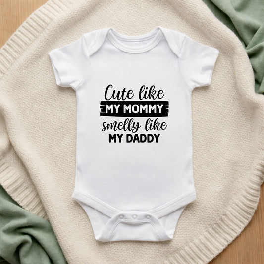 White baby onesie with text on a textured surface
