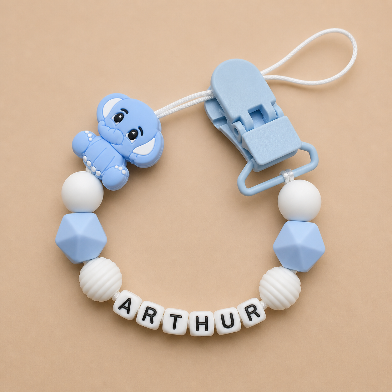 Baby pacifier clip with blue and white beads and a clip on a beige background