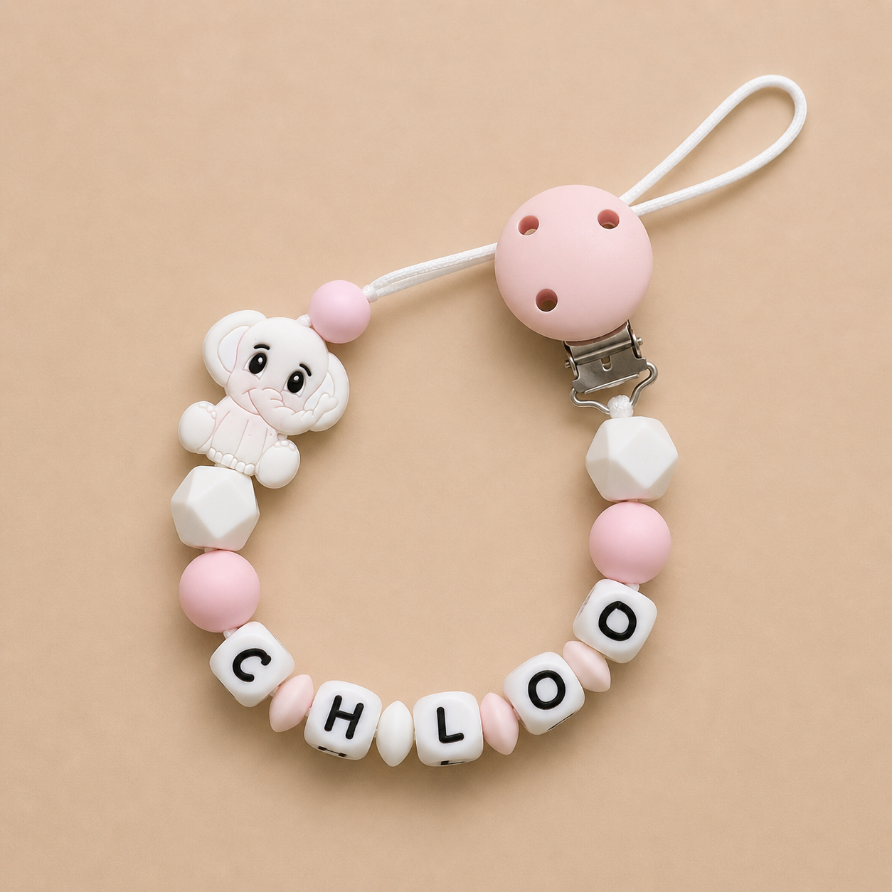 dummy clip with 'CHLOE' beads on a beige background