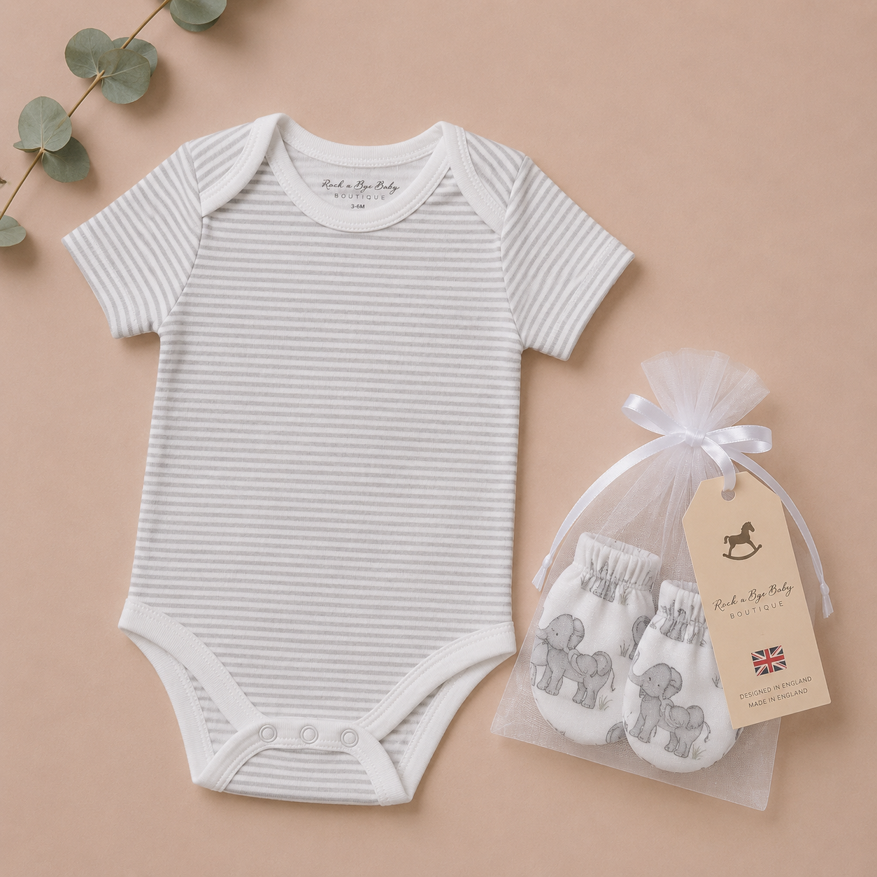Striped baby bodysuit and pouch with elephant design on a beige background