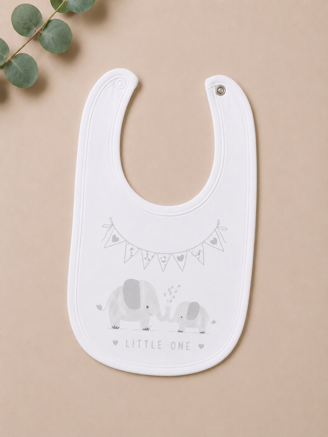White bib with elephant design and 'Little One' text on a beige background