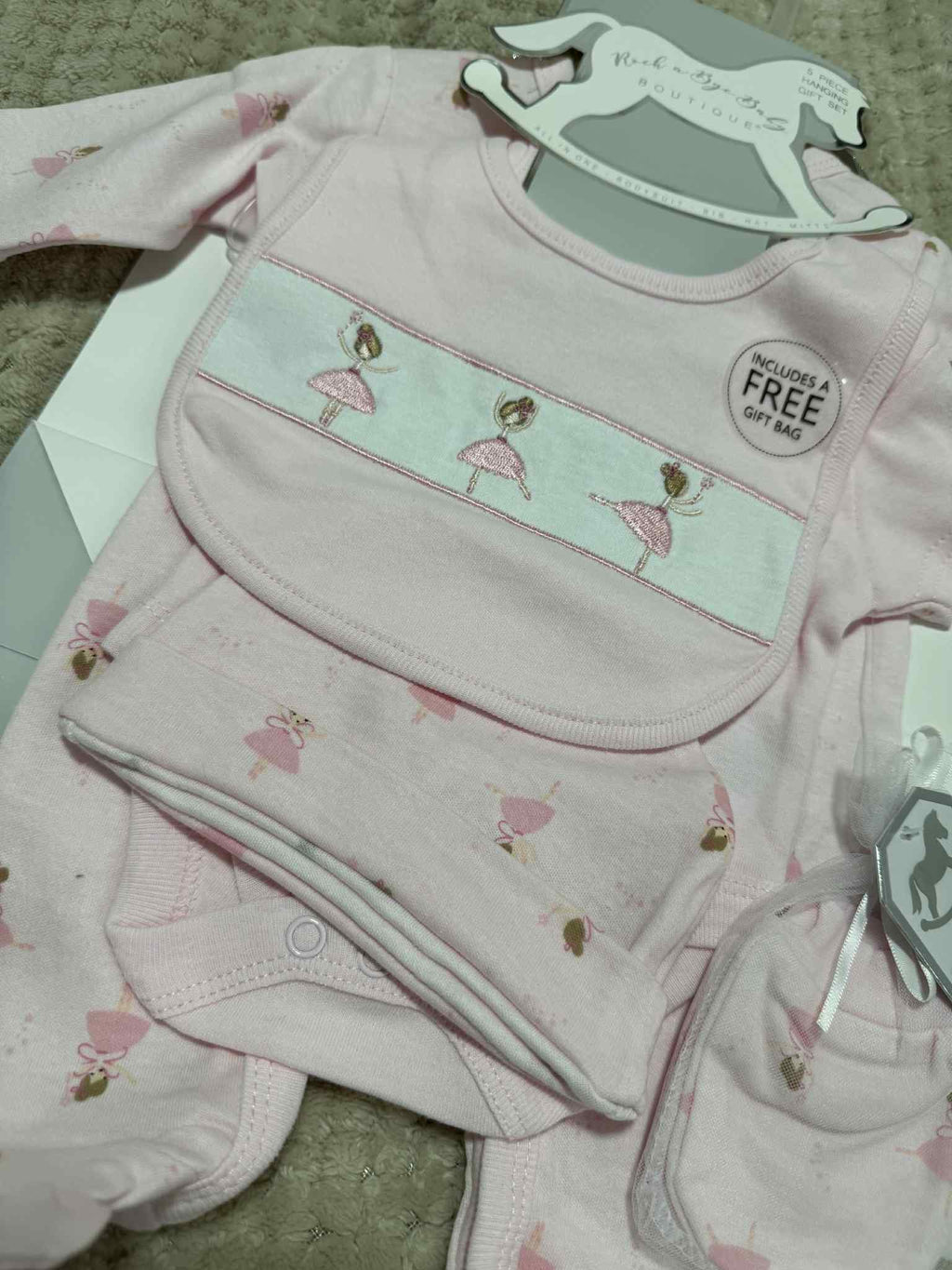 Pink baby outfit with fairy design on a textured surface