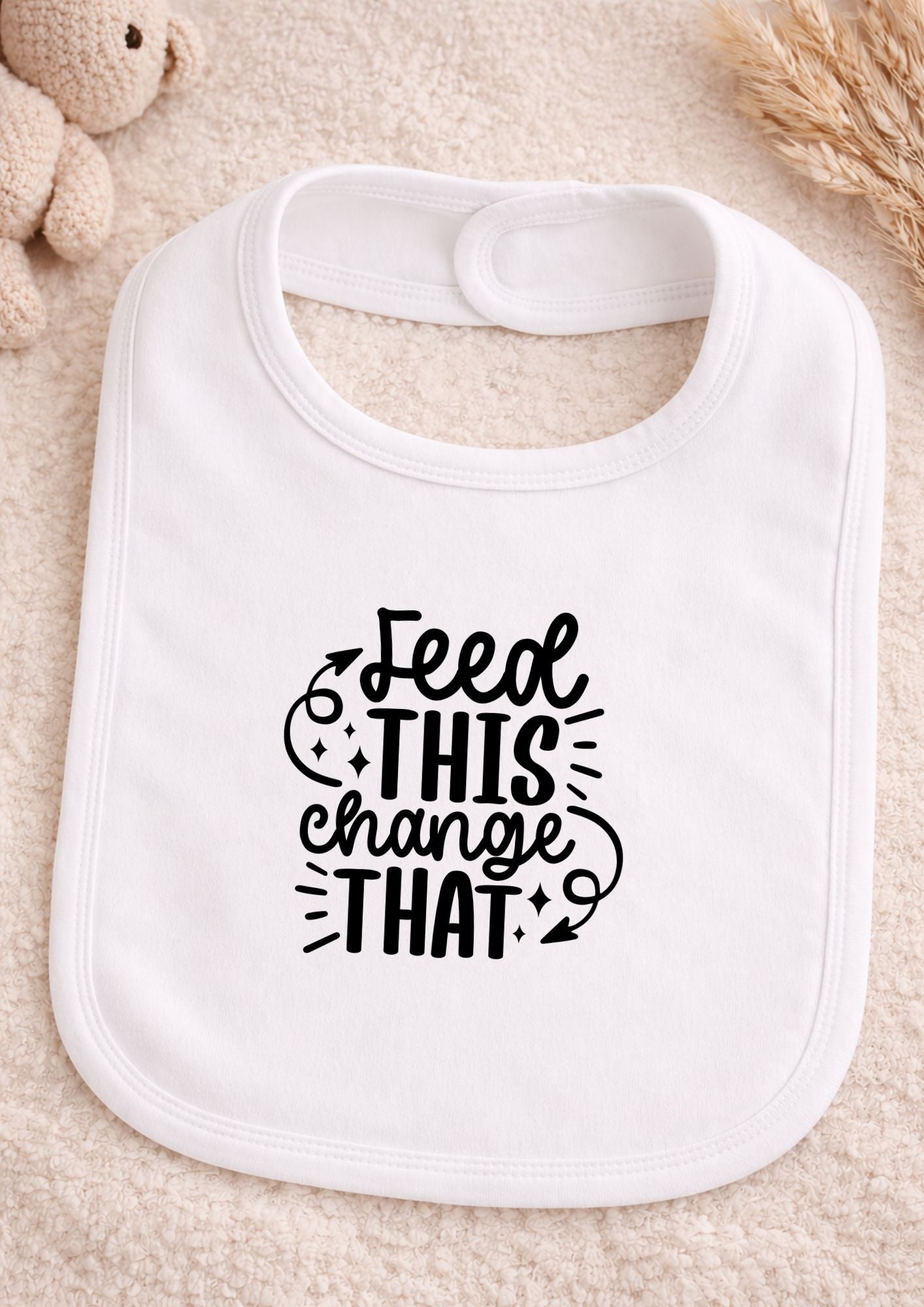White baby bib with black text on a beige surface