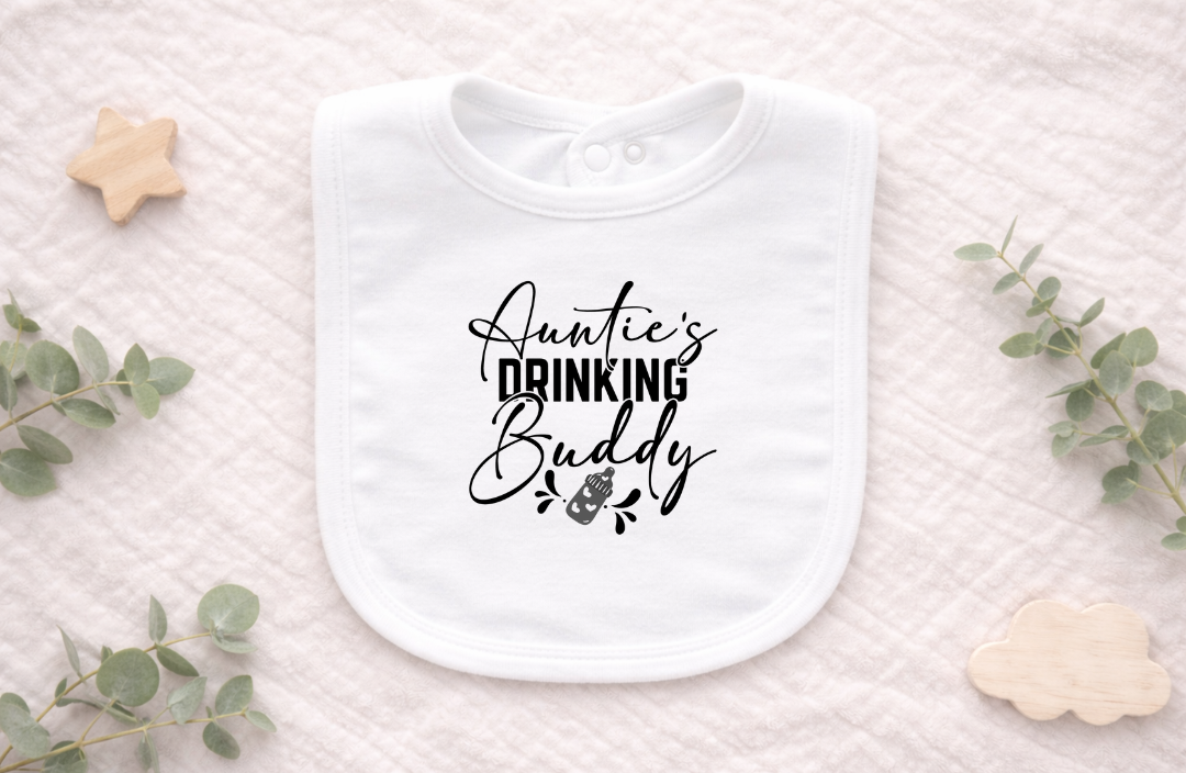 Cute newborn wearing a white baby bib with the phrase “Auntie’s Drinking Buddy,” perfect for baby showers and fun family photos.