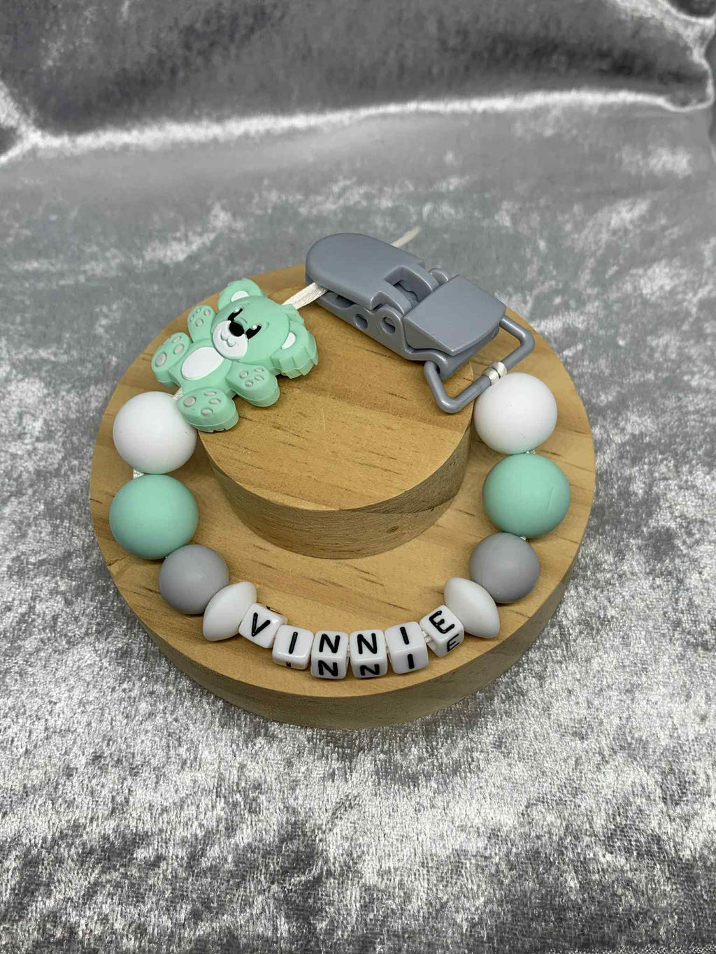 Mint Green, Grey and white teddybear dummy chain on a grey textured surface personalised with the name 'Vinnie'. Personalisation and MAM Adapter options available.