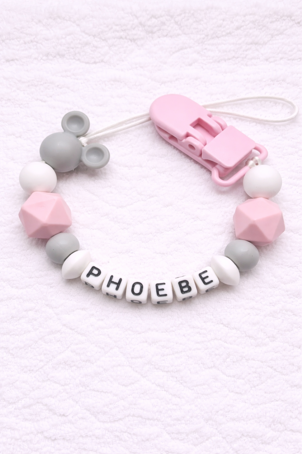 Dummy Clip with geometric beads and pink clip on a white background