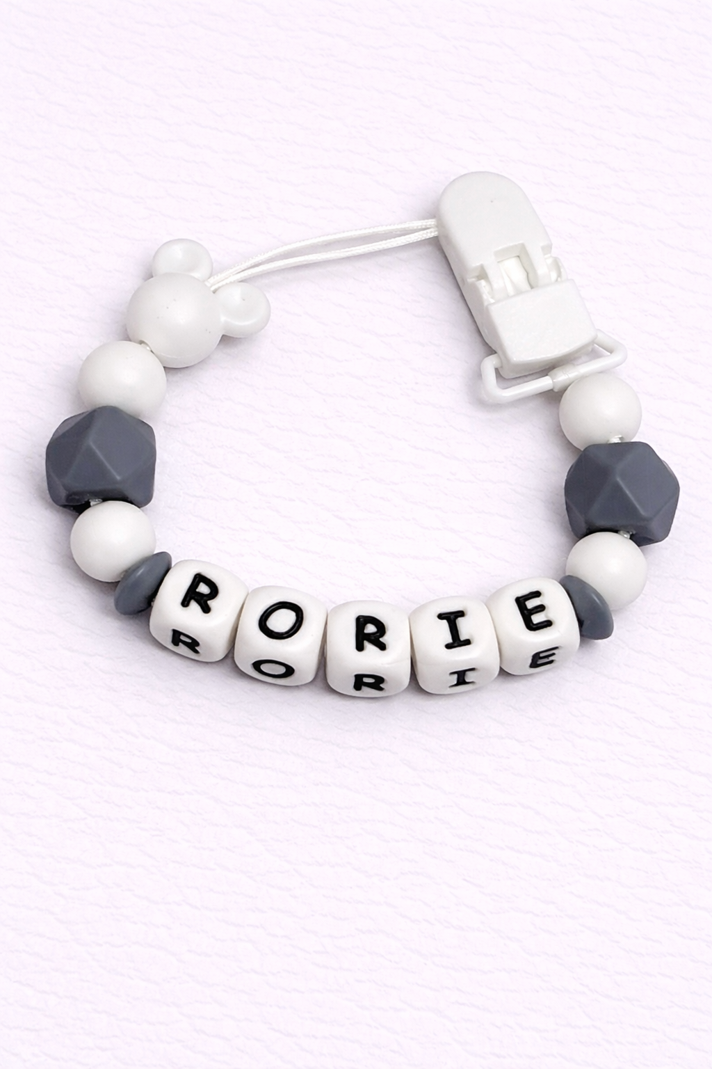 dummy clip with letter beads spelling 'Rorie' on a white background