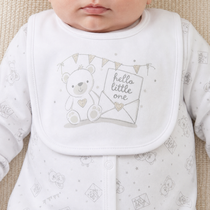 Baby bib with teddy bear design and 'hello little one' text on a textured surface