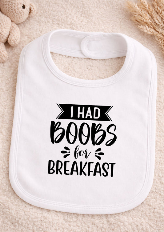 White baby bib with text on a beige surface