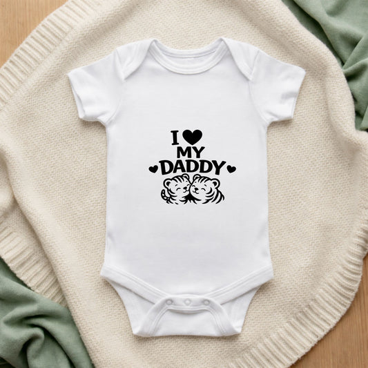 White baby onesie with 'I ❤️ MY DADDY' text on a textured surface