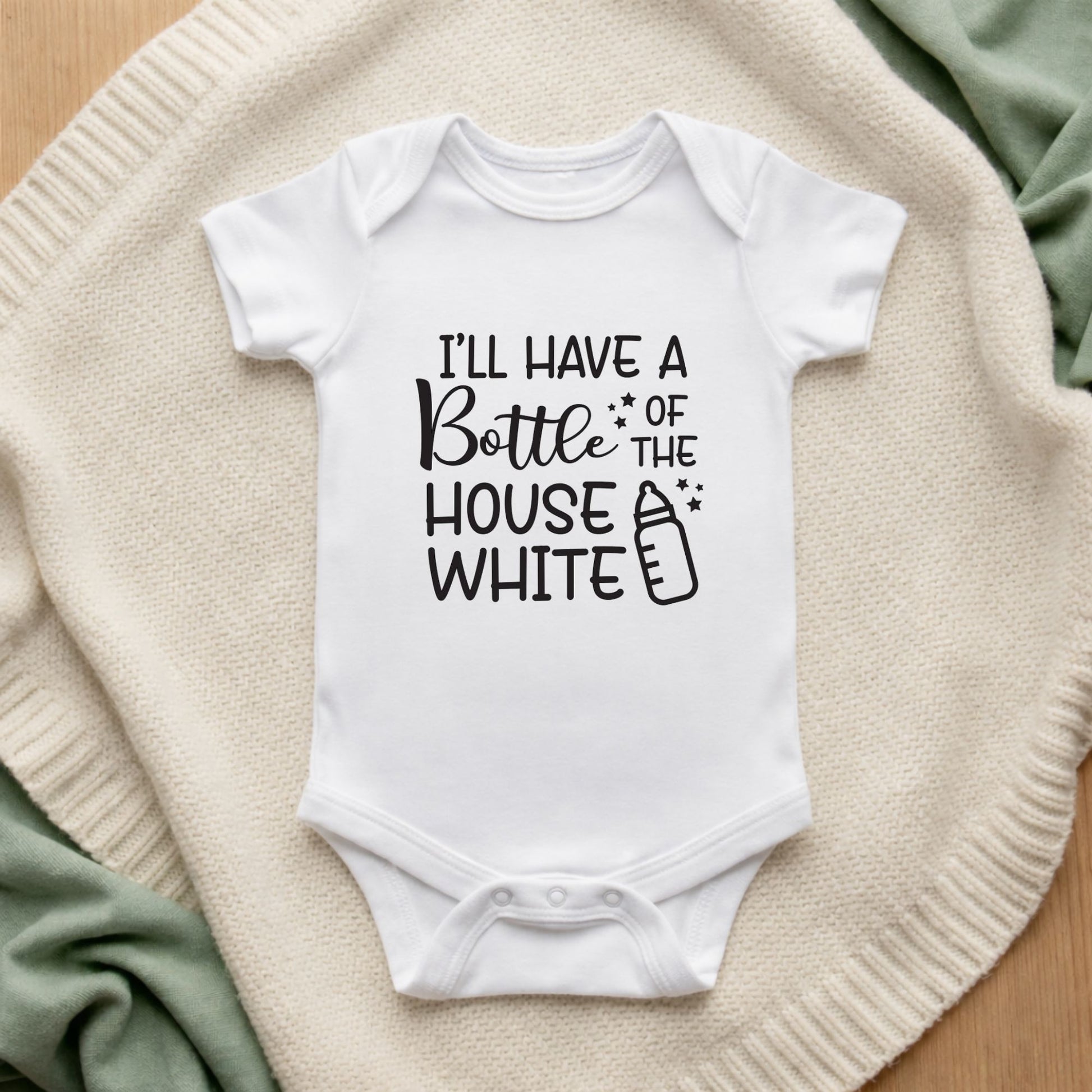White baby onesie with humorous text design on a textured surface I'll Have a Bottle of the House White Baby Vest