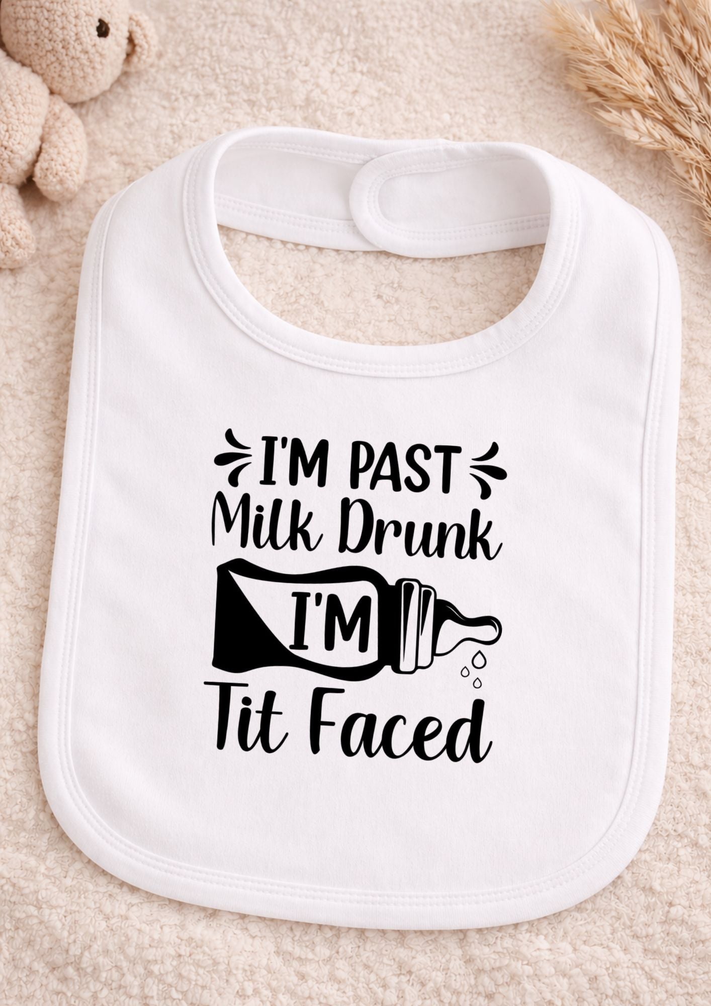 White bib with humorous text design on a beige surface