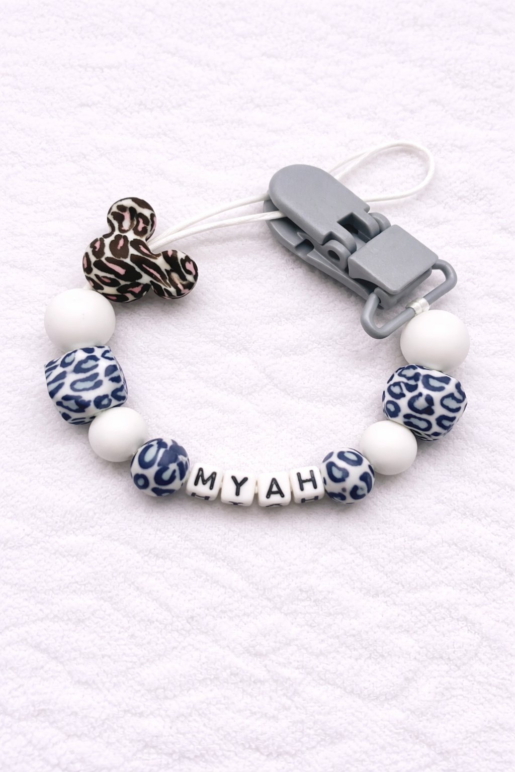 Dummy Clip with leopard print and white beads on a white background