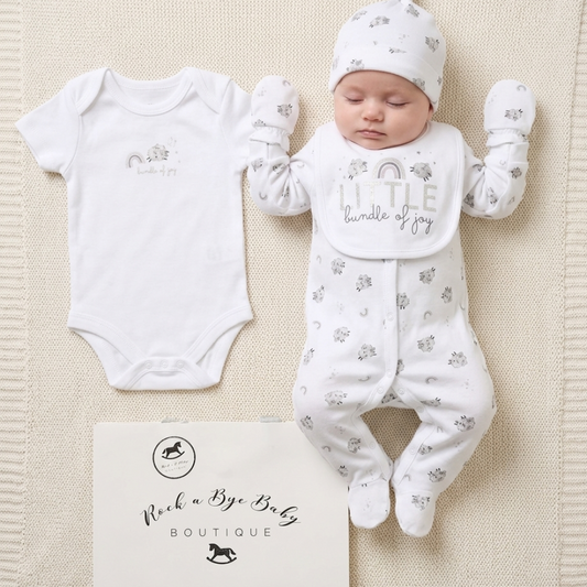Baby outfit set with onesie, romper, and hat on a textured surface with 'Rock a Bye Baby Boutique' branding.