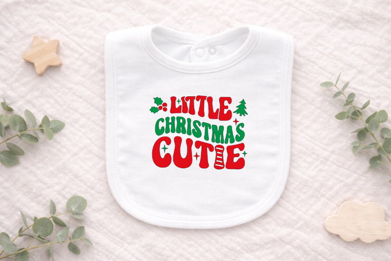 White baby bib with 'Little Christmas Cutie' text on a light background