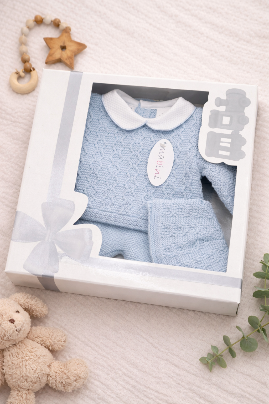 Baby blue knitted newborn boxset featuring a classic Spanish-inspired top, trousers, and hat, designed as an elegant newborn gift.