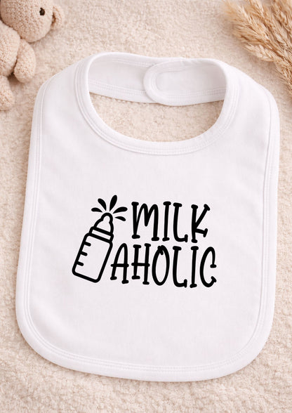 White baby bib with 'Milk Aholic' text on a beige surface
