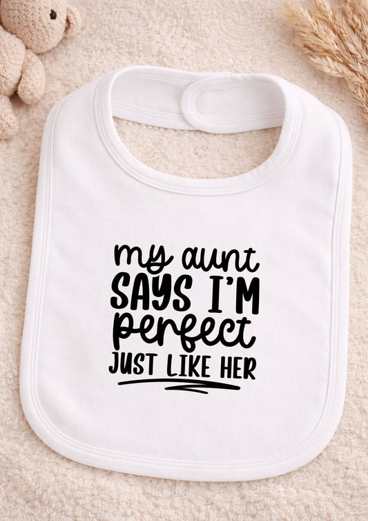 White baby bib with black text on a beige surface