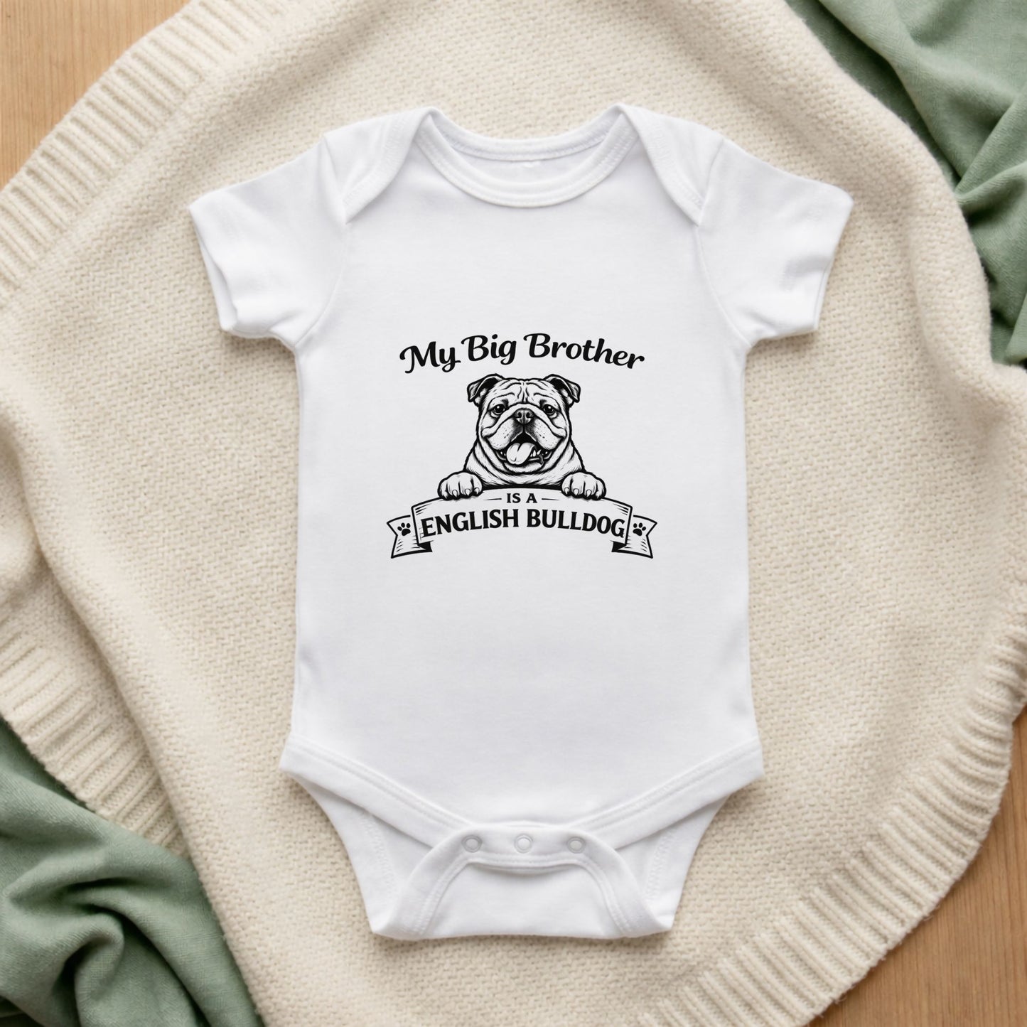 White baby onesie with 'My Big Brother is an English Bulldog' text and graphic on a textured surface.